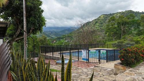 a building with a fence and a view of a mountain at Villa Cristina San Javier in La Mesa