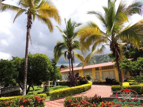 a building with palm trees and flowers in front of it at Villa Cristina San Javier in La Mesa