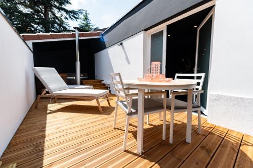 a patio with a table and chairs on a balcony at Suite D&S Luxury Room in Firminy