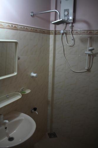 a bathroom with a shower with a sink and a mirror at Guillet Beach Home in Matara