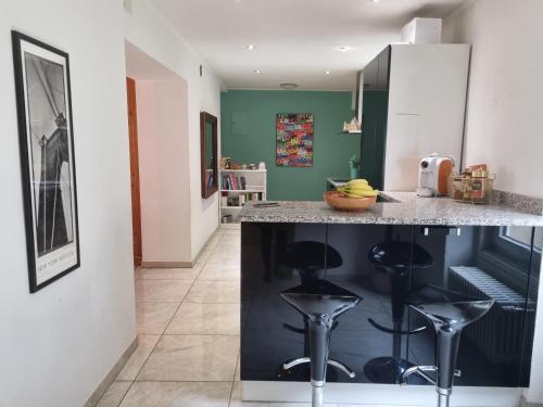 a kitchen with two bar stools and a counter at Family apartment in Poschiavo