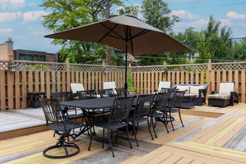 a black table and chairs with an umbrella on a deck at Lakeview East Apartment in Chicago