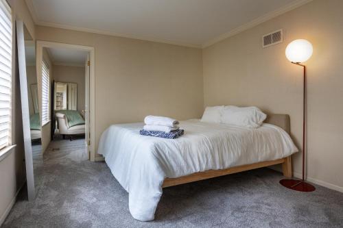 a bedroom with a bed with white sheets and a lamp at Lakeview East Apartment in Chicago