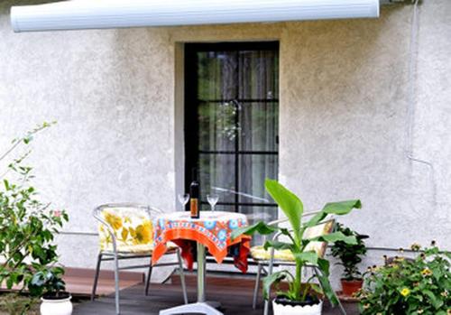 a table and chairs on a patio with a window at Eden 1 Zimmer Appartment in Hoppegarten