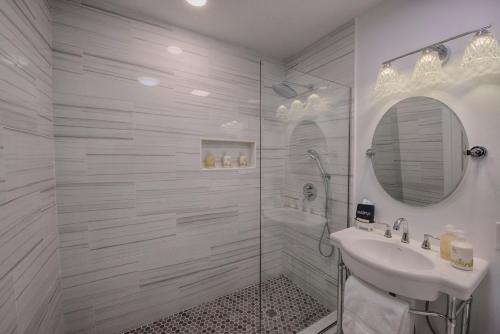 a white bathroom with a shower and a sink at Historic Tapoco Lodge Resort in Tapoco