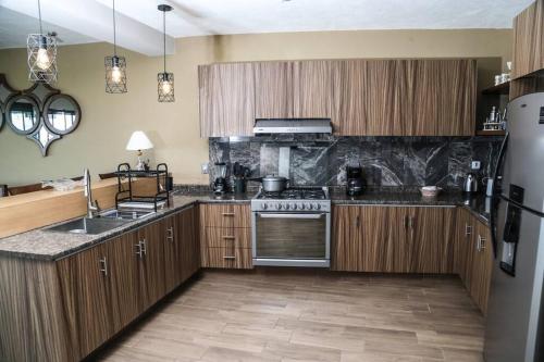 a kitchen with wooden cabinets and stainless steel appliances at Lake house 3 bedroom Pool and hotub in San Cristóbal Zapotitlán