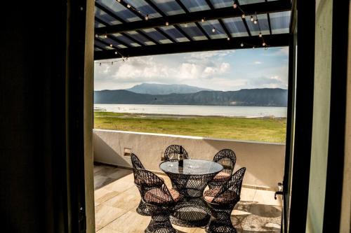 a table and chairs on a balcony with a view of the ocean at Lake house 3 bedroom Pool and hotub in San Cristóbal Zapotitlán