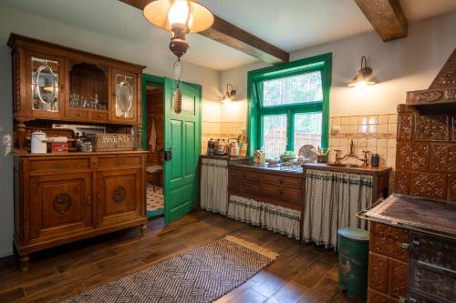 a kitchen with a green door and wooden cabinets at Chata w Leśnych Pieleszach - sauna & balia z jacuzzi na wyłączność in Łukawica