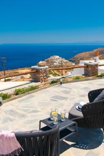 a patio with a table and chairs and the ocean at Windmill Bella Vista in Artemonas