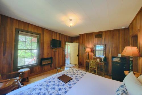 a bedroom with a bed and wood paneled walls at Historic Tapoco Lodge Resort in Tapoco