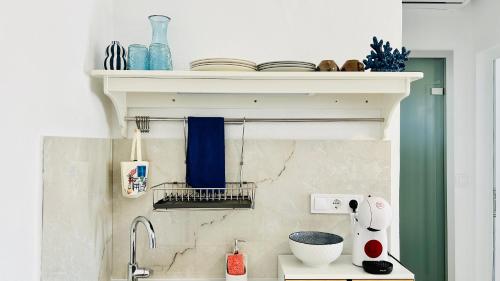 a kitchen with a shelf above a sink at Mirem Boutique Apartments, Central Apartments in Ofrínion