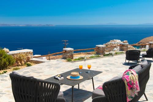 a patio with a table with two glasses of wine at Windmill Bella Vista in Artemonas