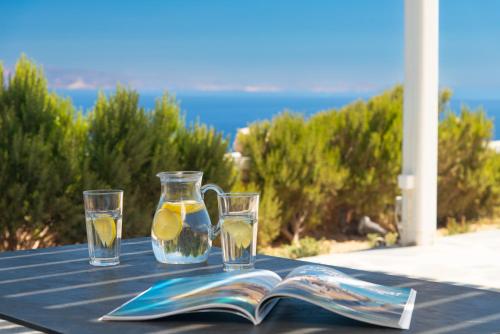 a table with two glasses and a book with a drink at Windmill Bella Vista in Artemonas