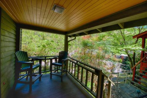 a screened porch with two chairs and a table at Historic Tapoco Lodge Resort in Tapoco