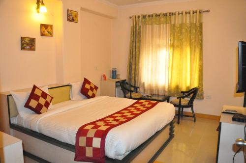 a hotel room with a bed and a window at Hotel Muskan Palace in Jaipur