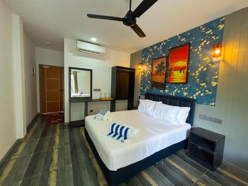 a bedroom with a large white bed with a blue wall at Mathiveri Thundi Inn in Mathiveri