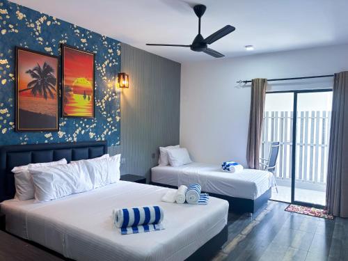 a bedroom with two beds and a ceiling fan at Mathiveri Thundi Inn in Mathiveri