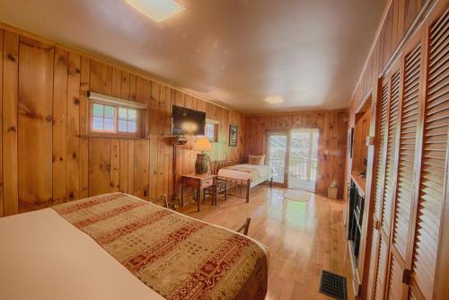 a bedroom with wooden walls and a bed in a room at Historic Tapoco Lodge Resort in Tapoco