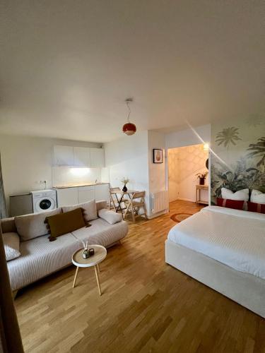 un salon avec un canapé et un lit dans l'établissement Appartement Rénové au Cœur du Quartier Commerçant, à Colombes