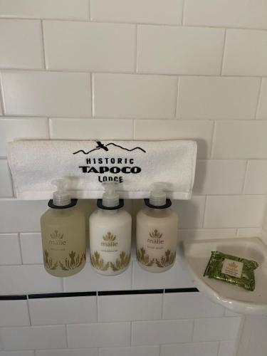 three complimentary taroco line bottles on a shelf in a bathroom at Historic Tapoco Lodge Resort in Tapoco