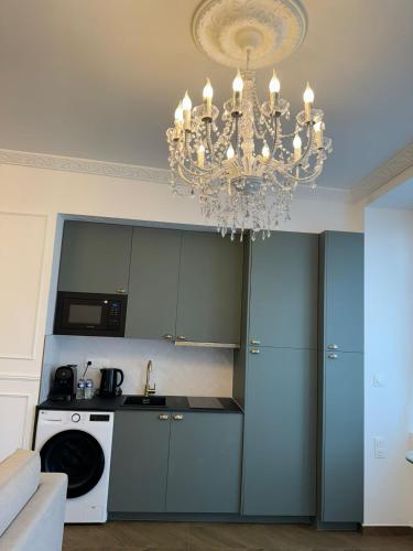 une cuisine avec un lustre suspendu au plafond dans l'établissement La Suite Haussmannienne, à Mitry-Mory