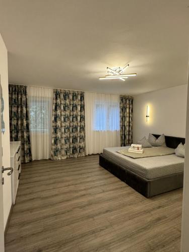 a bedroom with a large bed and curtains at Karlsburg Apartament in Alba Iulia