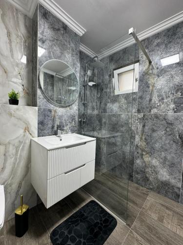 a bathroom with a white sink and a shower at Karlsburg Apartament in Alba Iulia