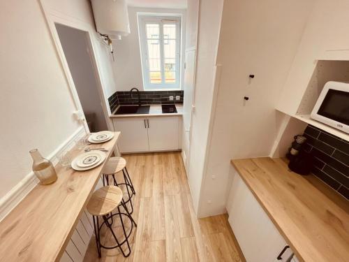 une petite cuisine blanche avec un comptoir et une télévision dans l'établissement La pastel - 339, à Rouen