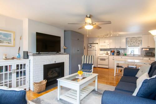 a living room with a fireplace and a tv at 1 2 Mile to Nantucket Sound Beaches in Dennis