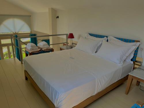 a bedroom with a large bed with white pillows at Aoni Suites in Aegina Town