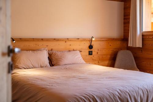 a bedroom with a white bed with a window at Chalet Ski Académie - Serre Chevalier in Saint-Chaffrey