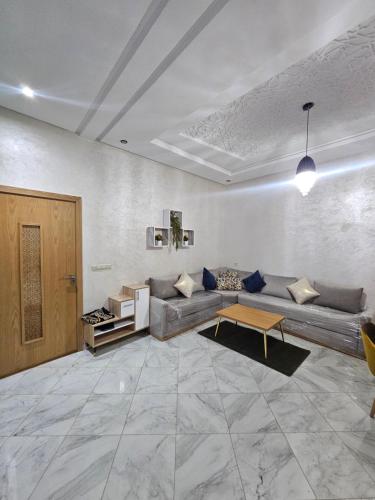 a living room with a couch and a table at Appartement bien équipé in Kenitra