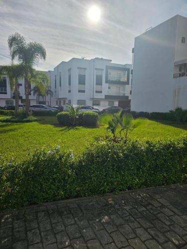 a grassy area with a building in the background at Appartement bien équipé in Kenitra
