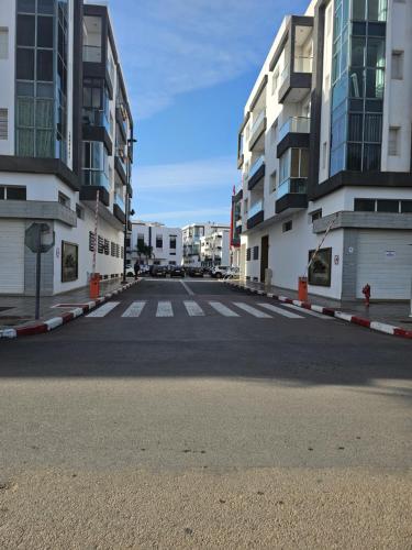 an empty street in a city with tall buildings at Appartement bien équipé in Kenitra