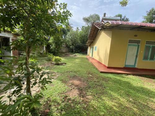 a house with a yard next to a building at NimSri Villa by Prazzventures in Mirissa