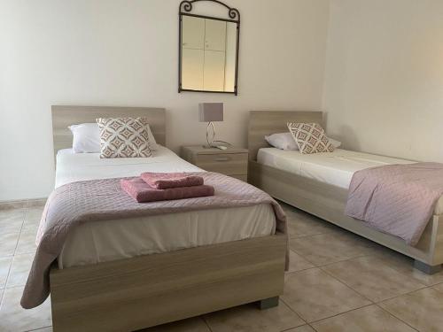a bedroom with two beds and a mirror on the wall at Polis Chrysochous Entire Apartment in Polis Chrysochous