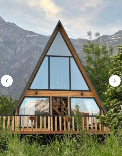 a frame cabin with glass windows in the mountains at Emotion Kazbegi in Stepantsminda