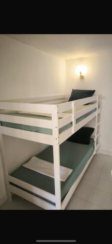 Ce lit superposé blanc se trouve dans un dortoir. dans l'établissement Appartement 4 personnes sea view pool, à Cannes