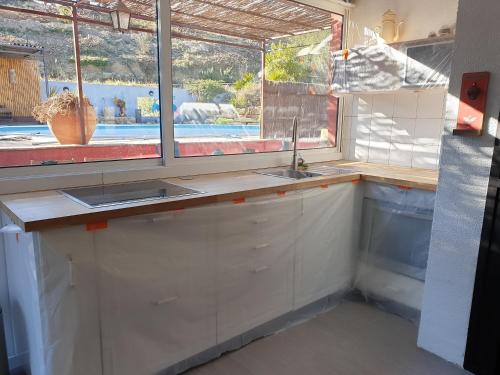 a kitchen with a sink and a window at Gîte dans Mas provençal ,havre de paix in Le Beausset
