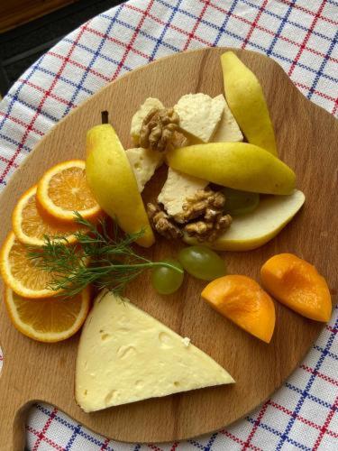 a plate of cheese and fruit on a table at Emotion Kazbegi in Stepantsminda
