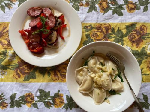 a table with two plates of food and a bowl of dumplings at Emotion Kazbegi in Stepantsminda