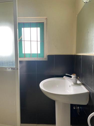 a bathroom with a white sink and a window at NimSri Villa by Prazzventures in Mirissa
