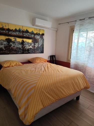 - une chambre avec un lit et une couette à rayures dans l'établissement Maison de vacances avec piscine et jacuzzi, à Carry-le-Rouet