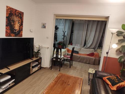 un salon avec une télévision à écran plat et un canapé dans l'établissement Maison de vacances avec piscine et jacuzzi, à Carry-le-Rouet