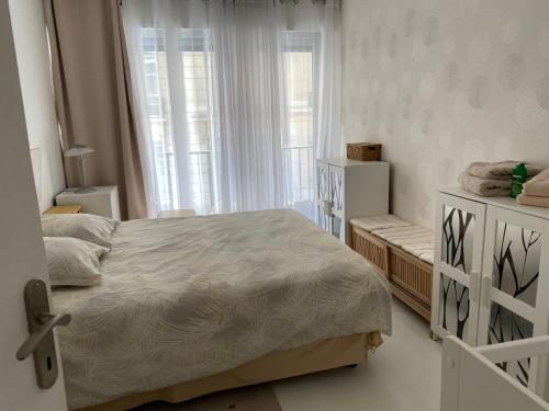 une chambre avec un lit et une grande fenêtre dans l'établissement Paris, à Paris