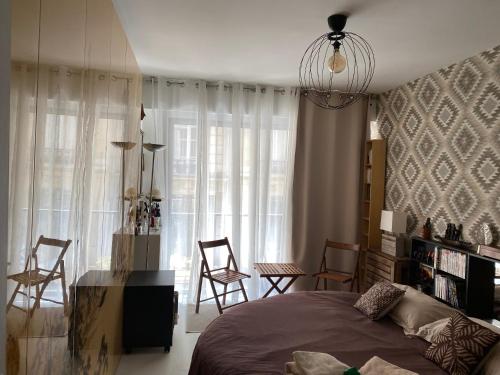 une chambre avec un lit et des chaises dans une pièce dans l'établissement Paris, à Paris