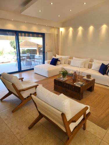 a living room with white couches and a table at Villa Solaris in Sounio