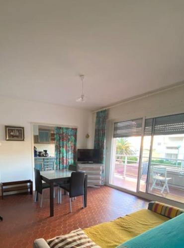 un salon avec une table et une salle à manger dans l'établissement Le Neptune place de Marbre plage et port, à Saint-Cyprien