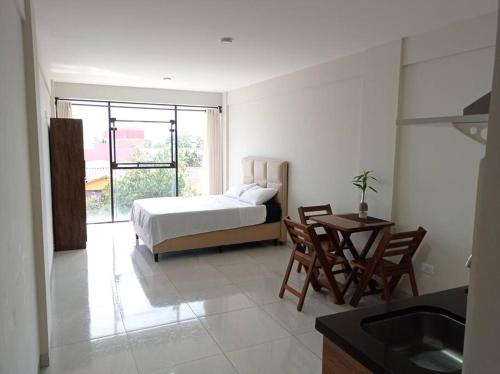 una camera da letto con un letto, un tavolo e delle sedie di Mono ambiente cómodo a Santa Cruz de la Sierra
