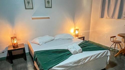 a bedroom with two beds and two lamps on tables at Pousada Mineiro 3 Irmaos in Arraial do Cabo